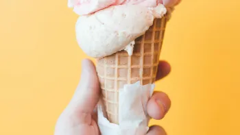 a hand holding a cone of ice cream