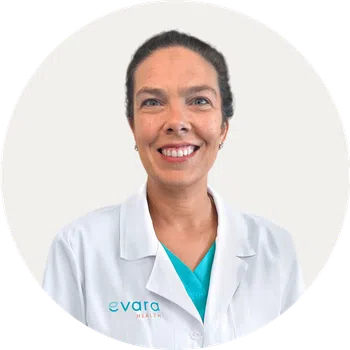 Smiling female healthcare professional wearing a white coat with Evara Health logo on light background