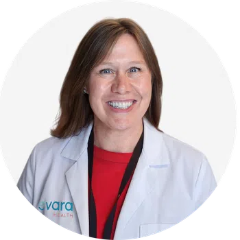Smiling female healthcare professional in white lab coat with Evora Health logo on a white background
