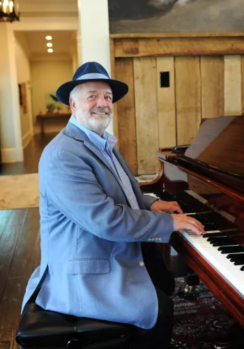 a man standing in front of a piano