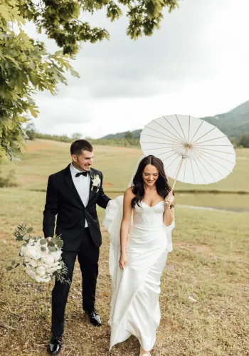 a man and woman walking down a path with an umbrella