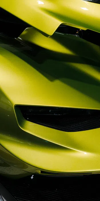 Close-up of a sleek lime green sports car front with aerodynamic curves and black grille details