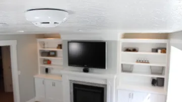 a room with a television and shelves