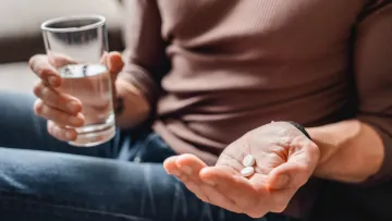 a person holding a glass of liquid