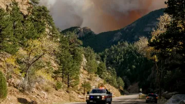 a car on a road with a cloud of smoke behind it