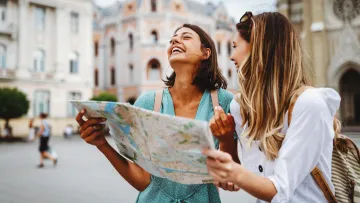 a couple of women looking at a map