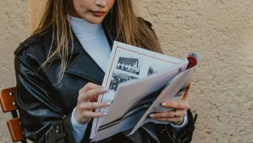 a woman sitting in a chair reading a book