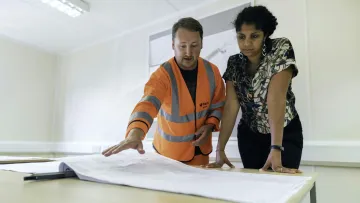 a man and a woman looking at a piece of paper