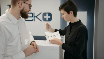 a man showing a woman something on a paper