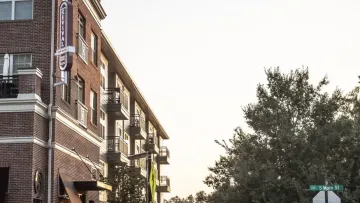 a street with a building and trees