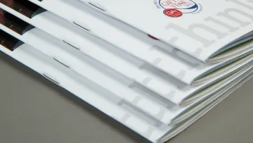 Stack of professional booklets with a clean design, featuring logos and modern graphics.