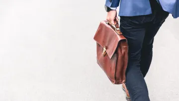a person holding a brown purse