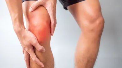 a close-up of a person with hands on sore knee