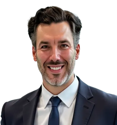 Smiling man with salt-and-pepper hair wearing a dark suit and blue tie against a transparent background