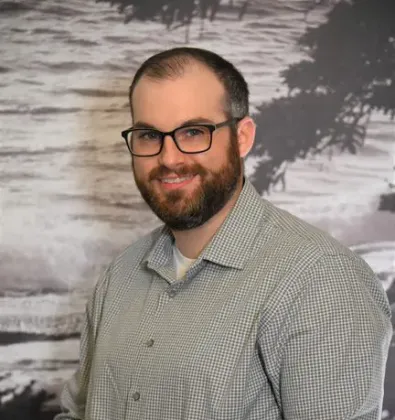 a man with glasses smiling