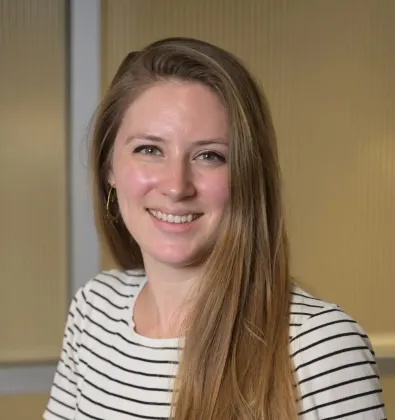 a woman smiling and folding her arms