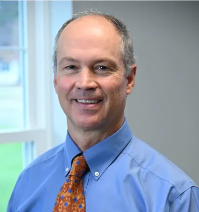 a man wearing a blue shirt and orange tie