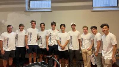 a group of men in white t-shirts standing in a room