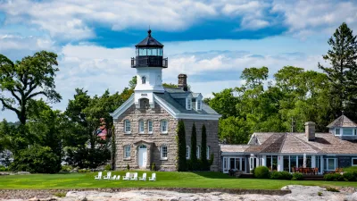 a large house with a light house with Mission Point Light in the background
