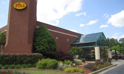a large brick building with a clock on the side of a road