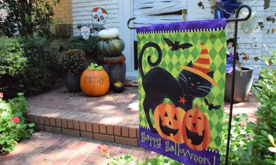 a decorative Halloween flag next to a home's front door