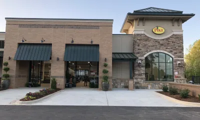 a large brick building with a clock on the side of a road