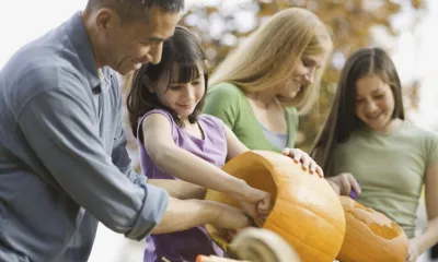 a family of four carving some pumpkins