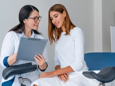 a woman showing a laptop to another woman