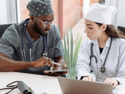 a man and a woman looking at a laptop