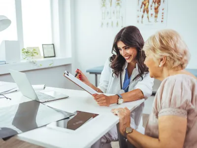 a woman showing a woman something on the paper