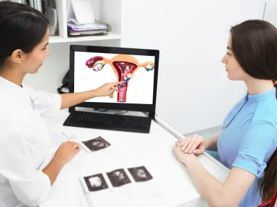 a woman showing a woman something on the computer