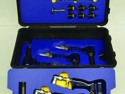 Black and gold industrial nozzles and components organized in blue foam inside a hard case.