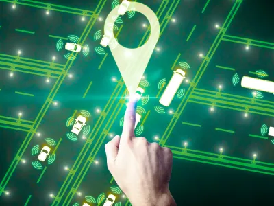 Hand touching a glowing location pin on a digital map with connected smart vehicles and data signals.