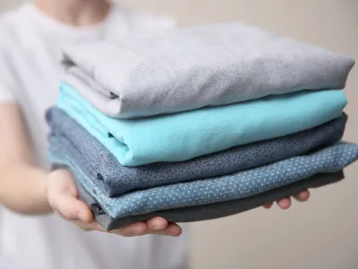 a person holding a stack of towels