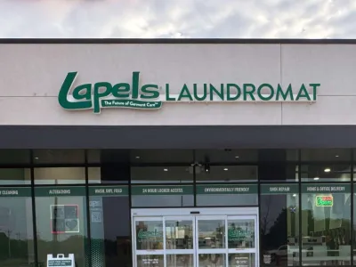Front view of Lapels Laundromat storefront with clear signage and glass doors on a cloudy day.