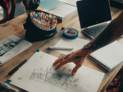 a desk with a laptop and a pen on it