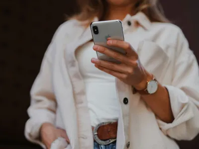 a person in a white coat holding a cell phone
