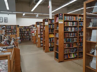 Interior of a bookstore with wooden shelves filled with books and a clean, well-lit pathway.