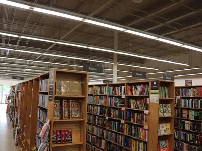 Interior of a bookstore with wooden shelves filled with books categorized by fiction, history, and religion sections.