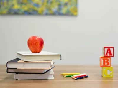 a red apple on top of a stack of books