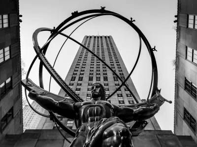 a statue of a person holding a torch in front of a large building