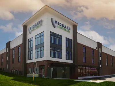 Modern Midgard Self Storage building with glass windows and brick facade under a cloudy sky.