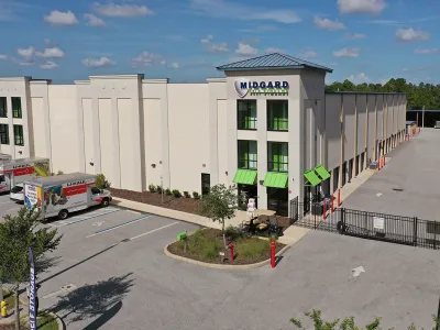 Modern Midgard self storage facility with U-Haul trucks parked outside on a sunny day
