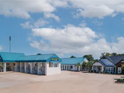 Midgard Self Storage facility with blue roofs, multiple storage units, and a clear sky with clouds.