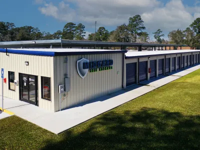Exterior view of Midgard Self Storage facility with multiple storage units and office on a sunny day.