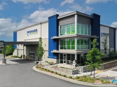 Modern Midgard Eye Center building with blue accents and large glass windows under a blue sky with clouds.
