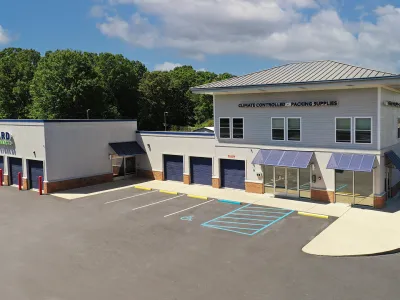 Exterior view of a climate controlled packing supplies facility with multiple storage units and parking spaces.
