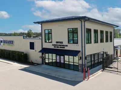 Modern self storage facility office with climate control and secure gated access under blue sky.