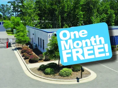 Self storage facility with gated entrance and promotional sign offering one month free rental.