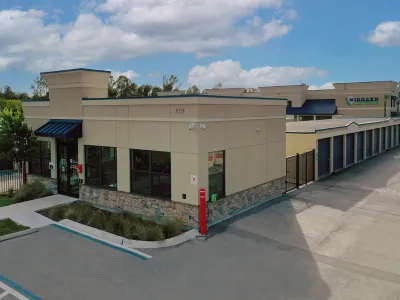 Midgard self-storage facility with office building, storage units, and clear blue sky on a sunny day.
